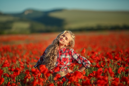 Portrait of a girl on the street with a wreath of poppy flowers on the head.の写真素材