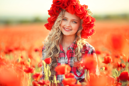 Portrait of a girl on the street with a wreath of poppy flowers on the head.の写真素材