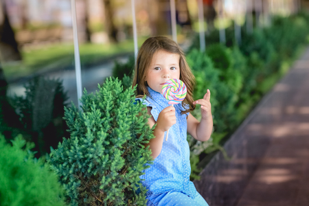 Child 5-7 years for a walk in the park with candy in his handの写真素材