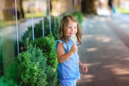 Child 5-7 years for a walk in the park with candy in his handの写真素材