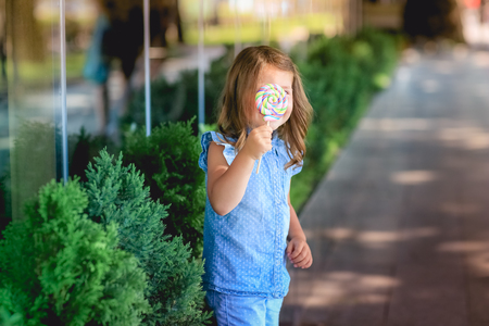 Child 5-7 years for a walk in the park with candy in his handの写真素材