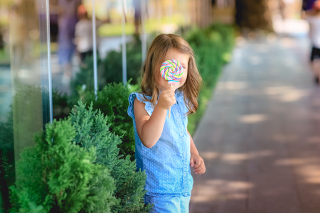 Child 5-7 years for a walk in the park with candy in his handの写真素材