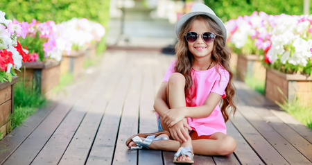 Fashion girl wearing a pink checkered shirt, hat and sunglasses in city.の写真素材