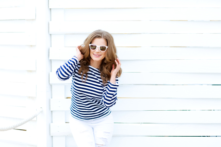 Girl in a striped shirt on a white wooden backgroundの写真素材