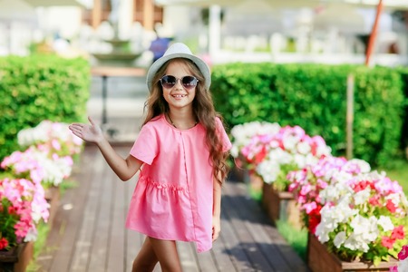 Fashion girl wearing a pink checkered shirt, hat and sunglasses in city.の写真素材