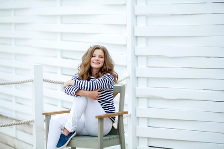 Girl in a striped shirt on a white wooden backgroundの写真素材