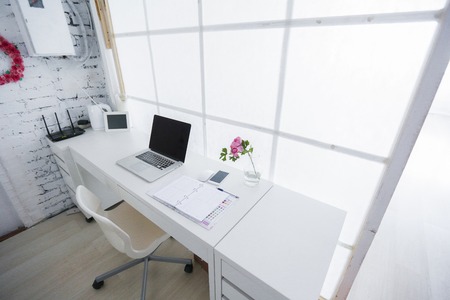 Modern interior workplace with laptop in white colors.の写真素材