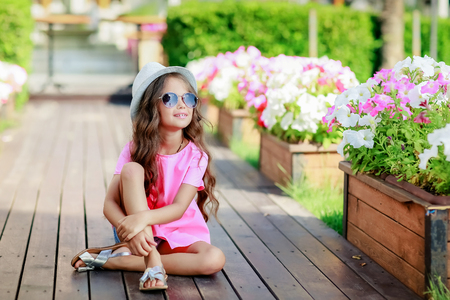 Fashion girl wearing a pink checkered shirt, hat and sunglasses in city.の写真素材