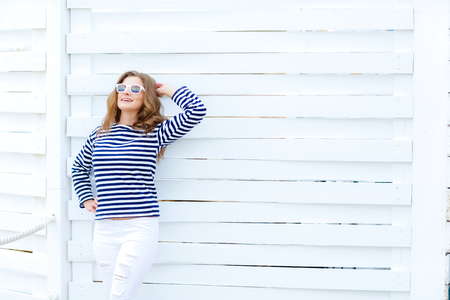 Girl in a striped shirt on a white wooden backgroundの写真素材