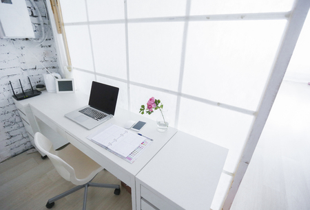 Modern interior workplace with laptop in white colors.の写真素材