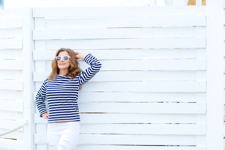 Girl in a striped shirt on a white wooden backgroundの写真素材