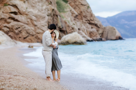 Vacation couple walking on beach together in love holding around each other. Happy interracial young couple, Woman and Caucasian man.の写真素材