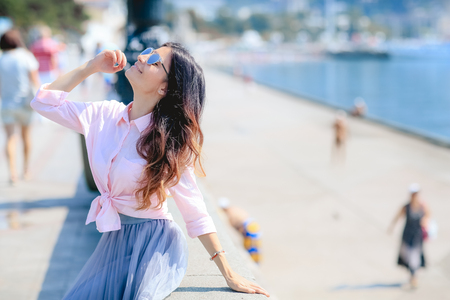 Happy woman by posing near the sea in a hot summer dayの写真素材