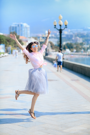 Happy woman by dancing across the sea in a winded dress.の写真素材