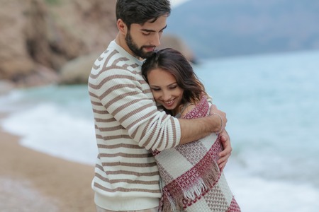 Young couple in love on the beach.Beautiful couple in white.Lovers holding hands and huggingの写真素材