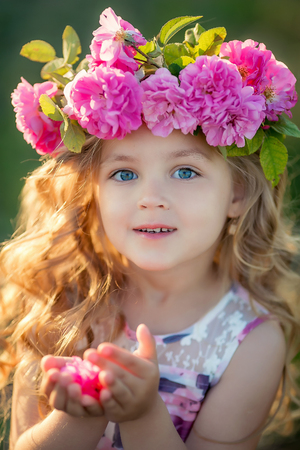 Smiling baby 3-4 year old standing with basket of flowers outdoors. Looking at camera. Summer seasonの写真素材