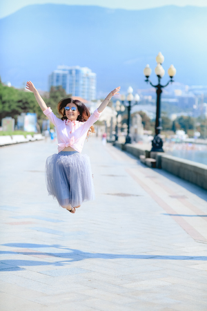 Happy woman by dancing across the sea in a winded dress.の写真素材