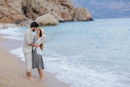 Vacation couple walking on beach together in love holding around each other. Happy interracial young couple, Woman and Caucasian man.の写真素材