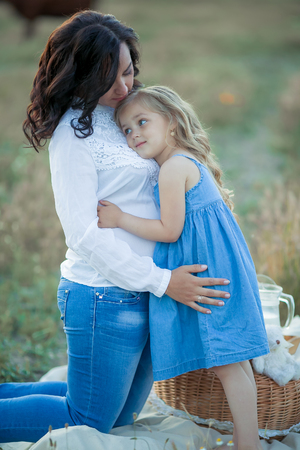 Happy mom and daughter. Picnic in the green park.の写真素材