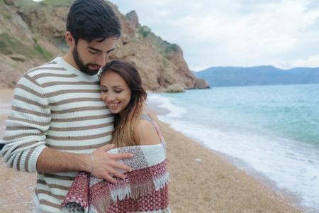 Young couple in love on the beach.Beautiful couple in white.Lovers holding hands and huggingの写真素材