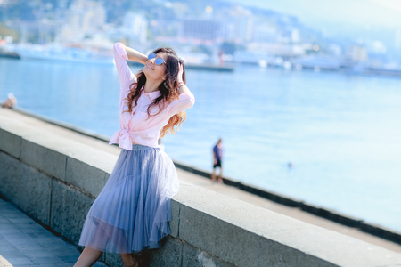 Happy woman by posing near the sea in a hot summer dayの写真素材