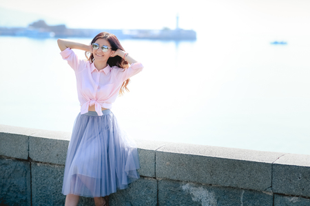 Happy woman by posing near the sea in a hot summer dayの写真素材