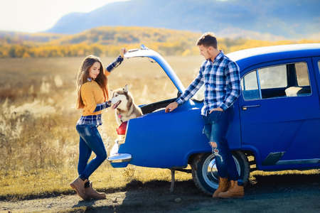 Portrait of a young family with a dog near a convertibleの写真素材