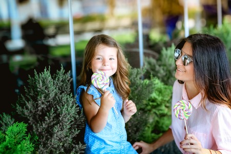 Mom and girl eating candy in the Park.