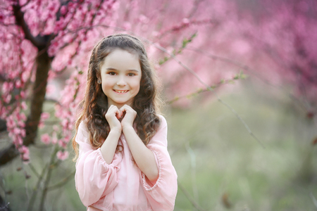 Beautiful young woman in pinkstylish garden dress blooming sakura.の写真素材