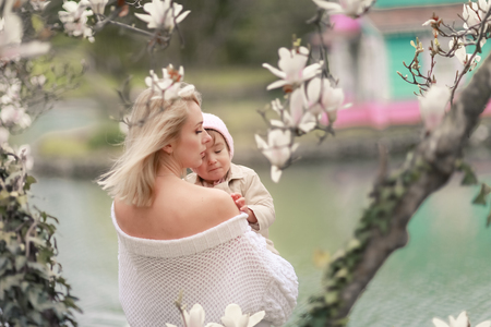 Happy family on a summer meadow. little girl child baby daughter hugging and kissing mother.の写真素材