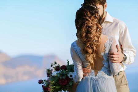 Wedding couple at breathtaking landscape with rock and sea.の写真素材