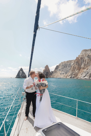 A Just married couple on yacht. Happy bride and groom on their wedding day.の写真素材