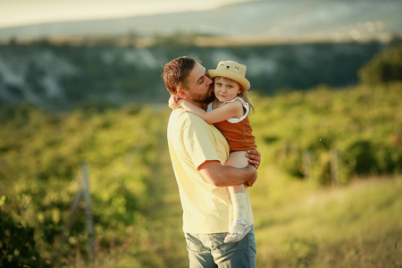 A Happy family walking history. mother and baby hugging in a meadow yellow flowers on nature in summer.の写真素材