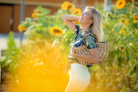 Beautiful lady walking in a sunflower fieldの写真素材