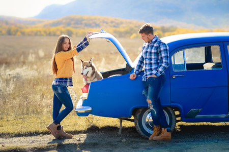 Portrait of a young family with a dog near a convertibleの写真素材
