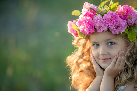 Smiling baby 3-4 year old standing with basket of flowers outdoors. Looking at camera. Summer seasonの写真素材