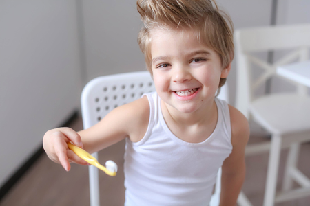 Boy cleans his teeth in the morning and plays with a toothbrush.の写真素材