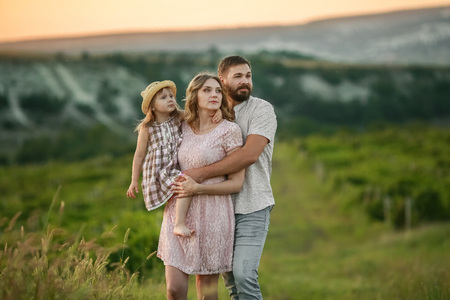 Happy family: mother father and child daughter on nature on sunset.の写真素材