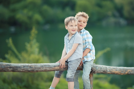 Two Boys Stand near Wooden Fence in Bavaria, Germany, Europeの写真素材