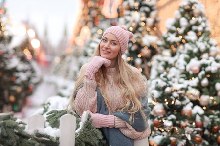 Close-up of a beautiful woman on a background of snowy Christmas trees.の写真素材