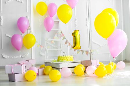 Yellow color concept of festive decorations with cake and candles 1 year.の写真素材