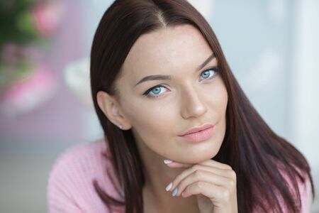 Close-up portrait of an incredibly beautiful woman dressed in pink pajamas.の写真素材