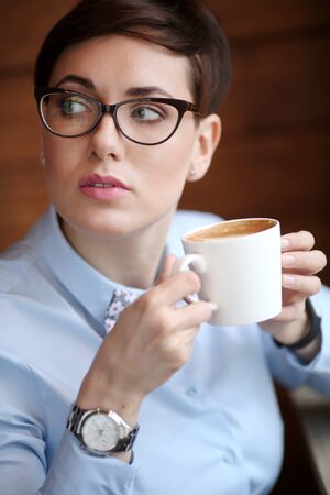 Business lady with a Cup of coffee during lunch break in the restaurant.の写真素材