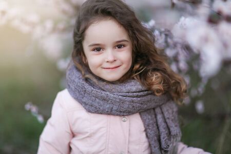 Portrait of a preschool girl in autumn in warm clothes and a scarf.の写真素材