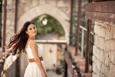 Beautiful woman of eastern appearance among ancient street stone architecture.の写真素材