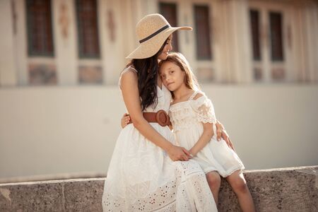 Young beautiful mother of eastern appearance walks with her daughter on the ancient streets of the Mediterranean city.の写真素材