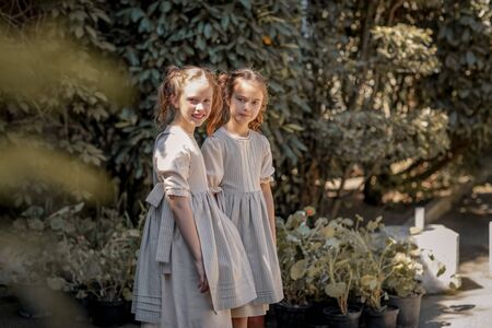 Two girls in school clothes have fun and play on the streets during the change.の写真素材
