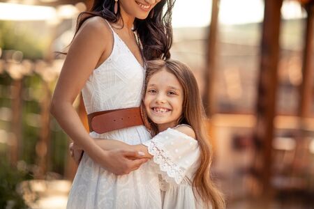 Young beautiful mother of eastern appearance walks with her daughter on the ancient streets of the Mediterranean city.の写真素材