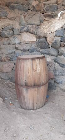 Wooden brown barrel against a stone wall.の写真素材