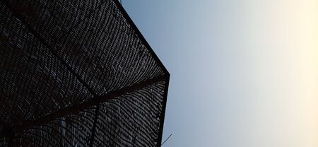 A projection of a straw canopy against a blue sky.の写真素材